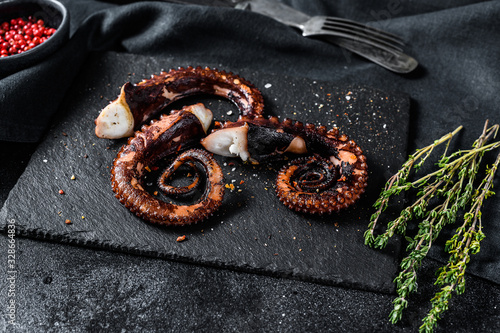 Grilled octopus tentacles. Fresh seafood. Black background. Top view