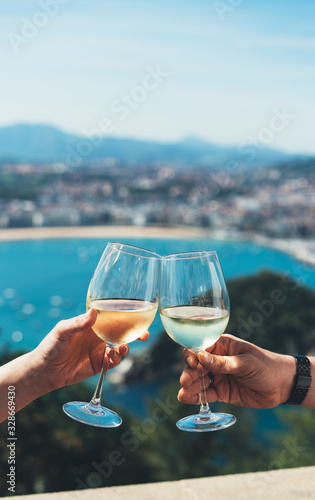 Canvas Print Drink two glasses white wine in friends hands outdoor seascape holidays, romanti