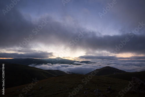 grassy mountains landscape with fog sky and sunset