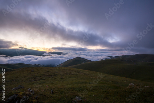 Fototapeta Naklejka Na Ścianę i Meble -  grassy mountains landscape with fog sky and sunset