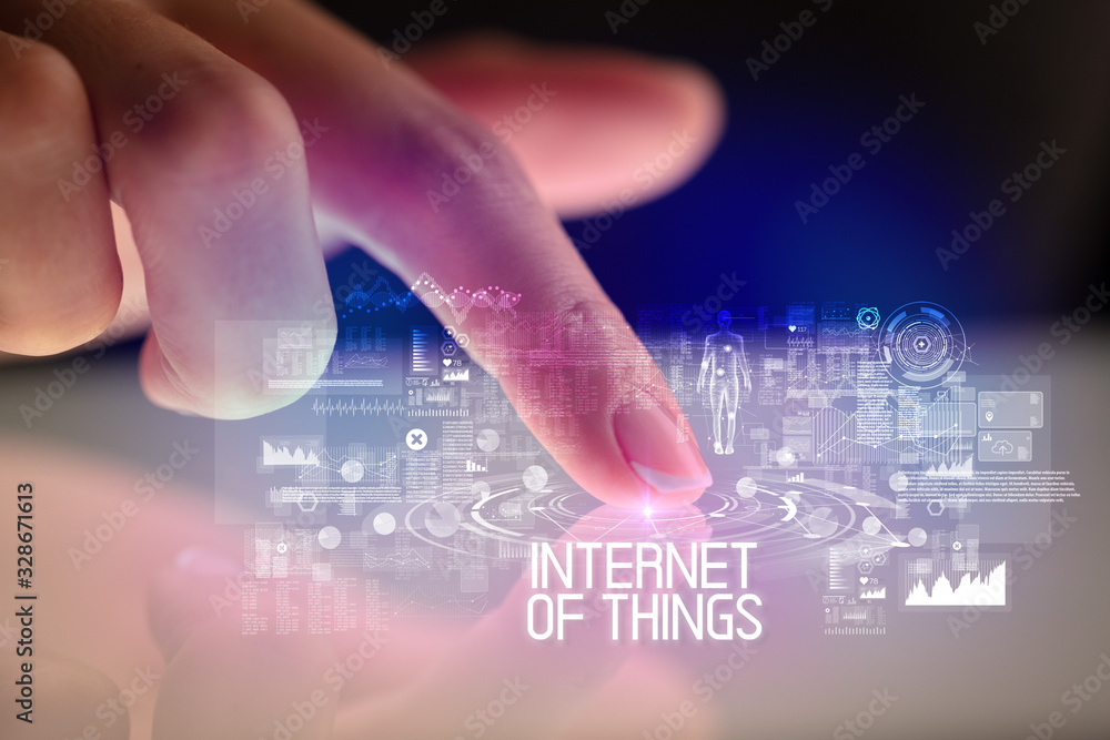 Finger touching tablet with web technology icons and INTERNET OF THINGS inscription Finger touching tablet with web technology icons and INTERNET OF THINGS inscription