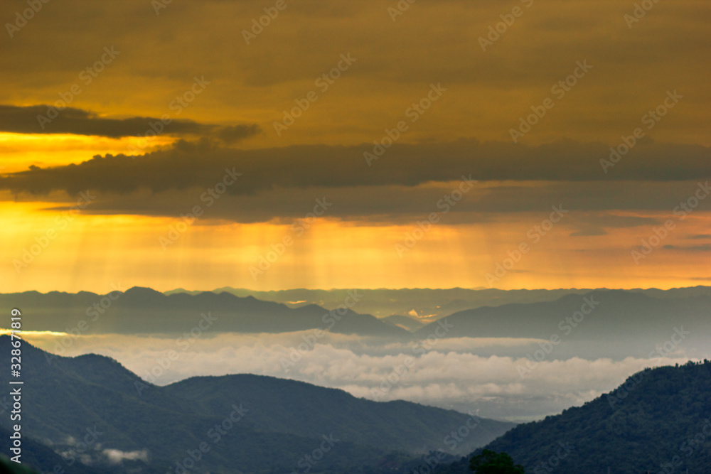 abstract background blur view of the sun shining through the clouds,surrounded by large mountains and various species of trees