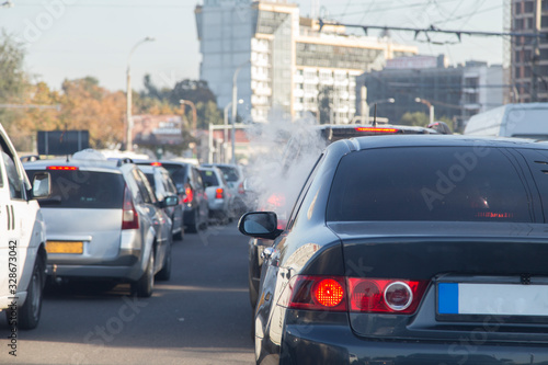 Vapour smoke go out from a car at a traffic jam. © indigolotos