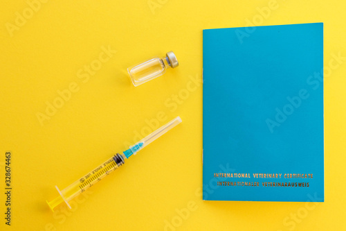 Syringe, glass vial with liquid and animal passport for indicating vaccinations and microchip number. International veterinary certificate. Cat or dog document ID. Health care and medicine concept,