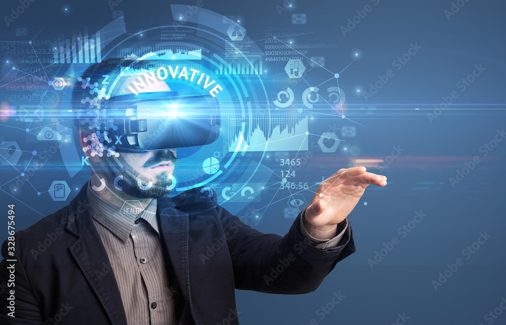 Businessman looking through Virtual Reality glasses with INNOVATIVE inscription, innovative technology concept Businessman looking through Virtual Reality glasses with INNOVATIVE inscription, innovative technology concept