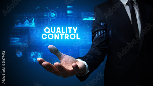 Hand of Businessman holding QUALITY CONTROL inscription, business success concept