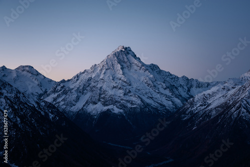 Majestic snowy high mountain early in the morning at dawn