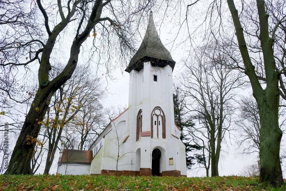 Moody landscape with white church among trees in autumn scenery. The church Nicholas in Kamien Pomorski, Poland