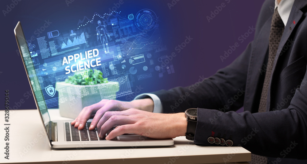 Businessman working on laptop with APPLIED SCIENCE inscription, cyber technology concept Businessman working on laptop with APPLIED SCIENCE inscription, cyber technology concept