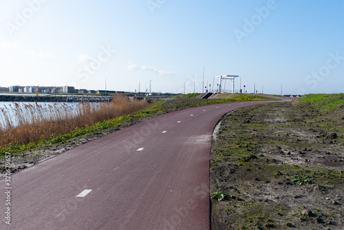 a cycle path with a bridge in the background on a sunny day. In Zeewolde Flevoland. March 7, 2020 the Netherlands. © robin