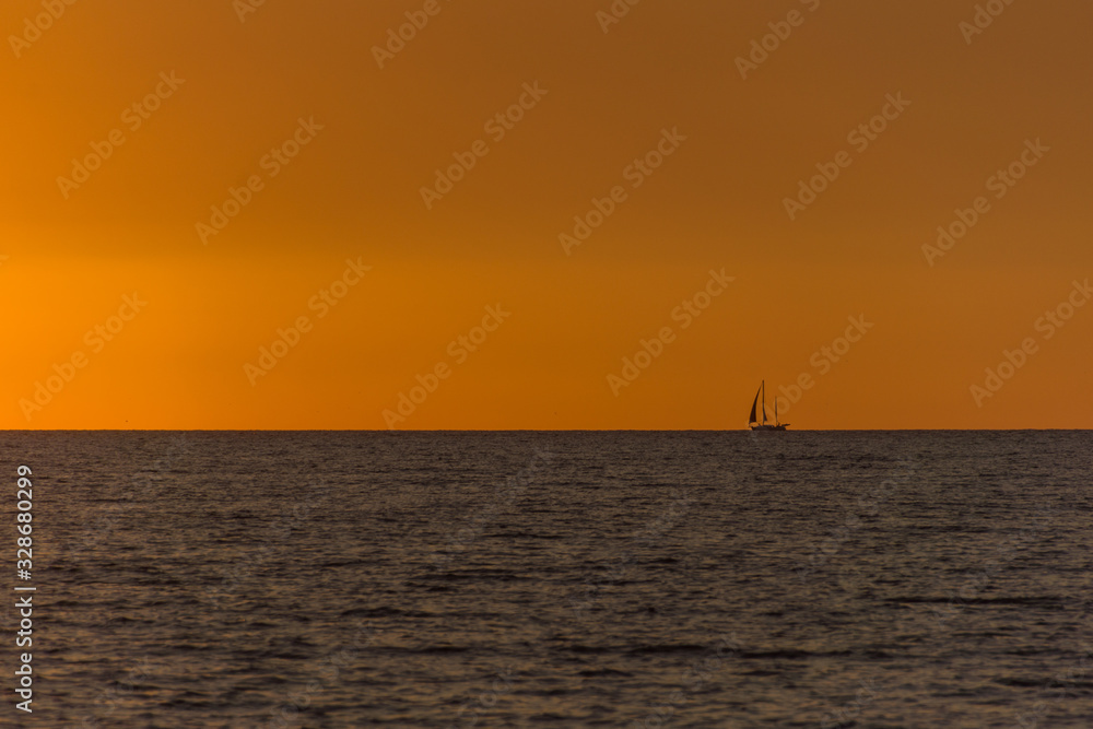 Sunset with a sailing boat on the horizon Sunset with a sailing boat on the horizon
