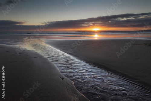 Last view of the sun as it sets over the horizon on Aberavon Beach in Port Talbot, South Wales, UK