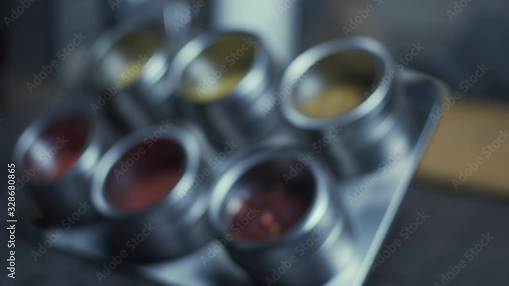 Set of steel pots with various spice, shallow depth of field, focus transition Set of steel pots with various spice, shallow depth of field, focus transition