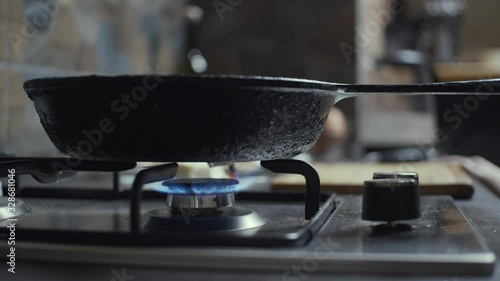 Gas stove ignition and putting pan on it, slow motion, shallow depth of field