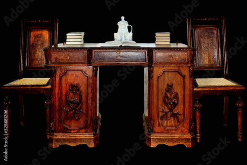 Fotografie old desk with chairs on a black background