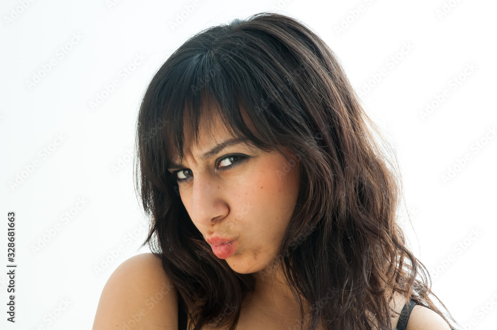 Very serious pretty brunette girl pulling a kiss, over white background Very serious pretty brunette girl pulling a kiss, over white background