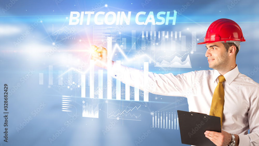 Handsome businessman with helmet drawing BITCOIN CASH inscription, architecture business plan concept Handsome businessman with helmet drawing BITCOIN CASH inscription, architecture business plan concept