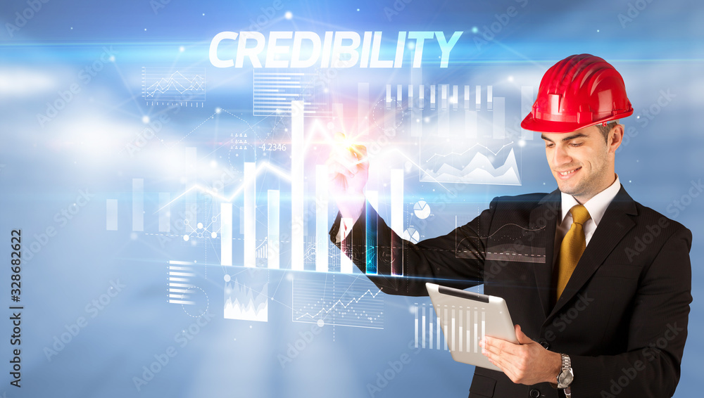 Handsome businessman with helmet drawing CREDIBILITY inscription, architecture business plan concept Handsome businessman with helmet drawing CREDIBILITY inscription, architecture business plan concept