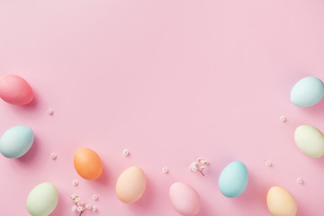 Pastel Easter eggs on pink background top view. Flat lay style.
