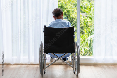 Senior man in his wheelchair with his back in hospital.