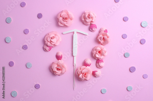 Concept hormonal contraception - pills and IUD. Paper flower, copyspace