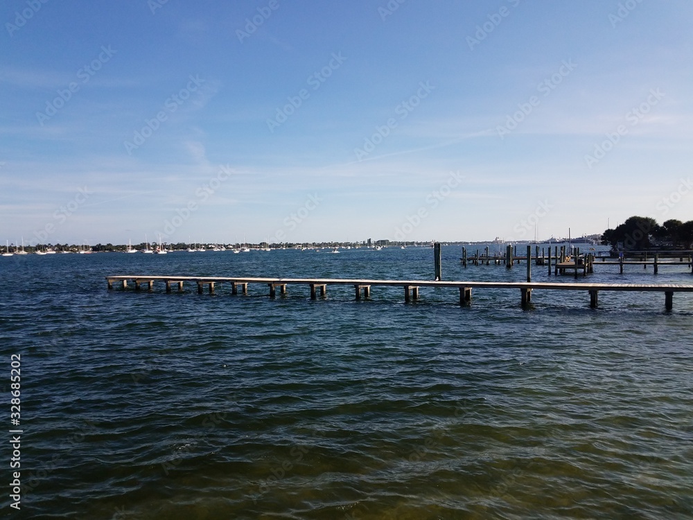 long wood pier with boats and sea water