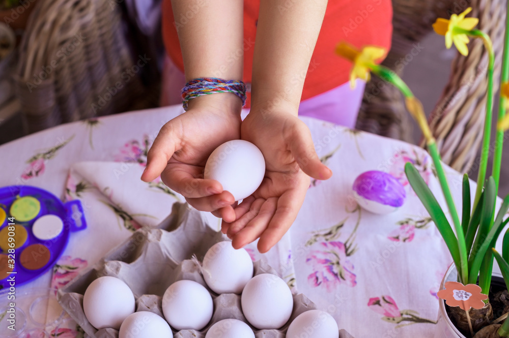 Little girl holding a bright Easter egg in her hands. Happy Easter Sunday celebration. Copy space Little girl holding a bright Easter egg in her hands. Happy Easter Sunday celebration. Copy space