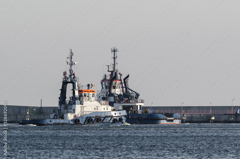 TUGBOATS - support vessels are maneuvering at the seaport