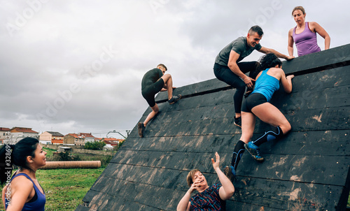 Group of participants in an obstacle course climbing a pyramid obstacle photo