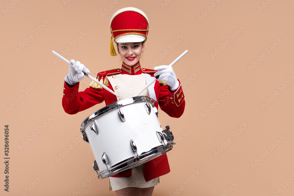 Naklejka premium drummer in a red uniform drums on a drum, show program and celebration.