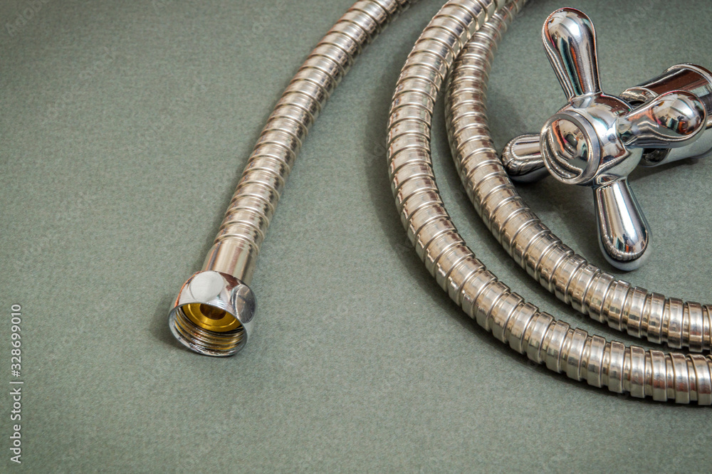 Plumbing materials faucet and hose on dark background are used for replacement in the shower Plumbing materials faucet and hose on dark background are used for replacement in the shower
