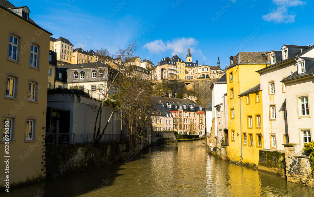 Luxembourg City - view of the Alzette river in the Grund lower neighborhood with beautiful colorful houses and blue skies