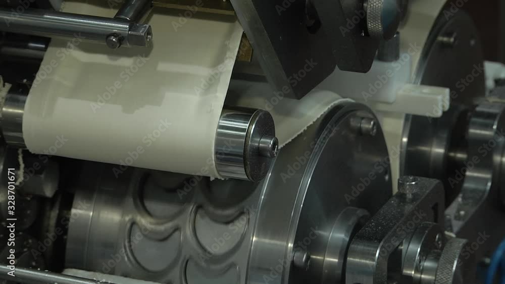 Manufacture of semi-finished products. Dumplings on the assembly line. Ravioli factory. Factory for the production of dumplings. Pelmeni production. Feed industry. Dumpling machine view Manufacture of semi-finished products. Dumplings on the assembly line. Ravioli factory. Factory for the production of dumplings. Pelmeni production. Feed industry. Dumpling machine view