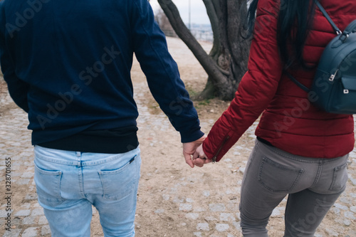 man and woman holding hands in park