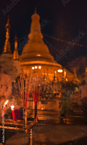 Shwedagon Pagoda incents and candles burning in front of golden stupa
