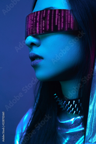 Neon portrait of a girl of Asian appearance, dressed in futuristic clothes and glasses. Neon blue and pink light. Virtual reality glasses and binary code in them.