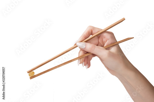 the female hand holds raisin wooden sticks is isolated on a white background