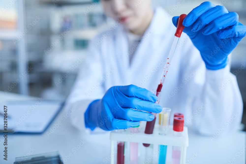 Horizontal shot of unrecognizable Asian woman doing laboratory tests for new medication development Horizontal shot of unrecognizable Asian woman doing laboratory tests for new medication development