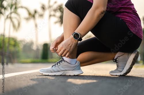 closeup of young woman runner tying her shoelaces. healthy and fitness concept.