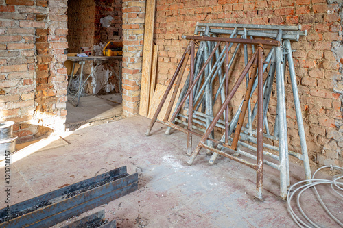 Fototapete on a building site, 2 scaffolding trestles lean against a brick wall