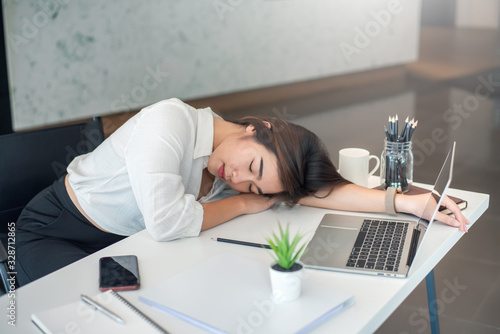Fotografía Tired businesswoman sleeping on the desk in the office