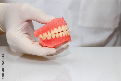 False teeth prosthesis. Doctor Dentist. A dental technician holds a false jaw in his hand.