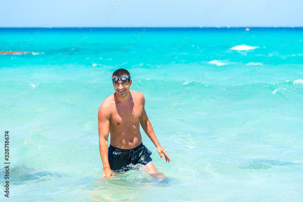 Attractive young caucasian man in the sea , wearing glasses. Summer vacation concept.
