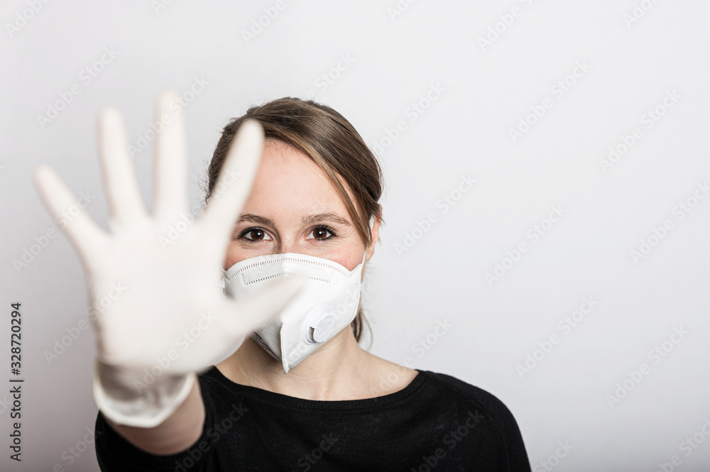 Frau mit Mundschutz und Handschuhe stoppt die Corona Virus Pandemie Frau mit Mundschutz und Handschuhe stoppt die Corona Virus Pandemie