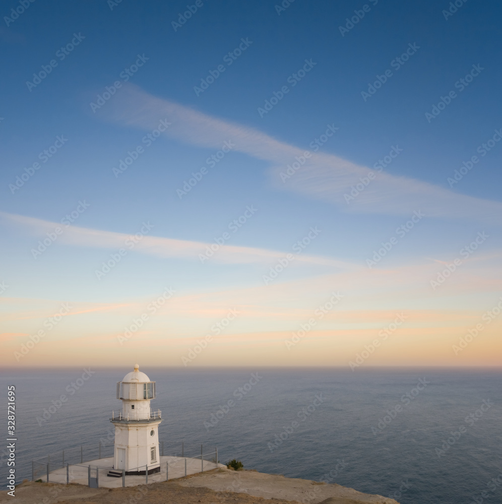 lighthouse on a marine cape at the twilight
