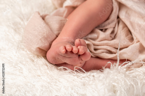 Newborn baby on a white blanket. tiny baby feet closeup. concept of happiness. place under the text