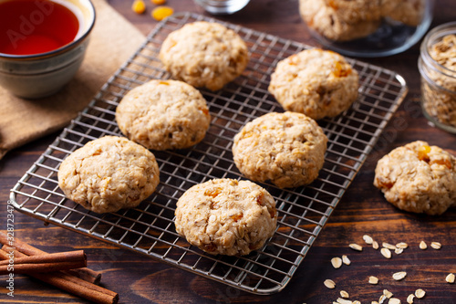 Oat vegan cookies on cooling rack with cup of tea. Wooden background.