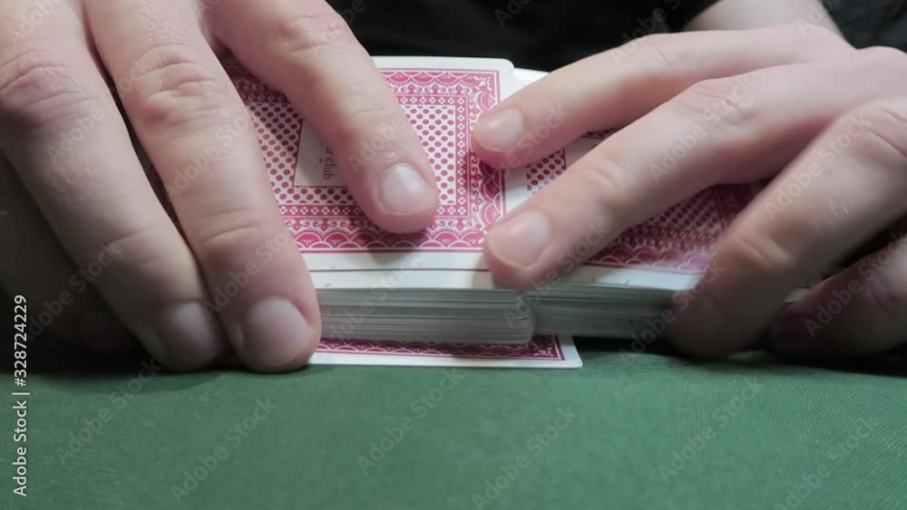 Riffle Shuffle. Male hand shuffling cards on a green cloth. Close-up. Gambling. Games of chance Riffle Shuffle. Male hand shuffling cards on a green cloth. Close-up. Gambling. Games of chance