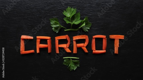 Stop motion animation of carrot sticks writing carrot on slate background