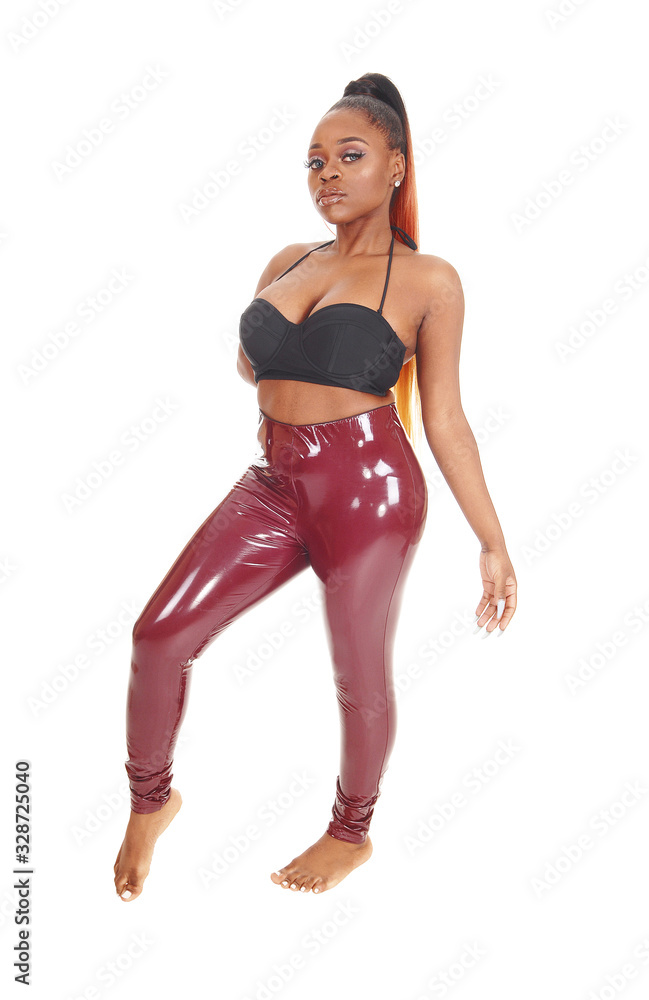 Elegant African woman standing in a red latex pants Stock-Foto | Adobe Stock
